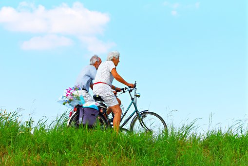 exercise for elderly man and woman cycling bikes 